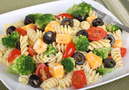 Pasta salad with vegetables and cheese cubes.
